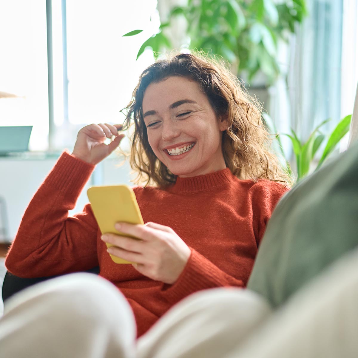 Smiling banking customer using her phone to do mobile banking.